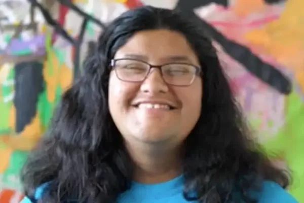 Aida Farias in front of a mural