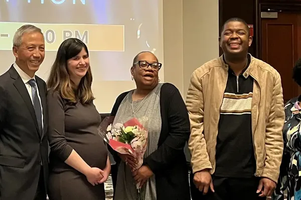 A group of six people standing at an awards reception in front of a screen displaying 'The Arc of Illinois 75 Years Awards Reception.'