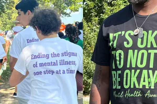 People in outdoor community setting wearing mental health awareness campaign t-shirts with supportive messaging.