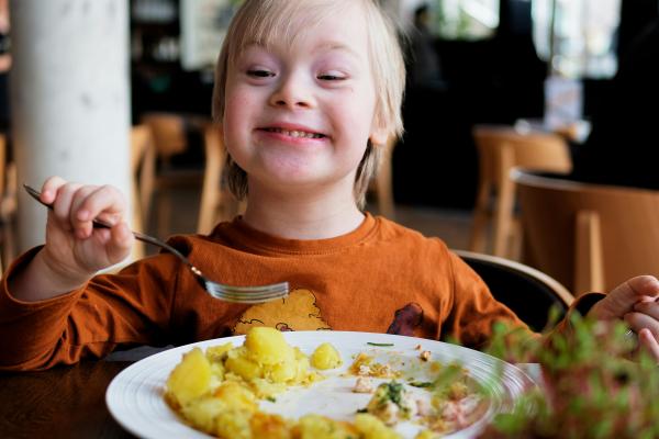 A child is seen happily enjoying a meal