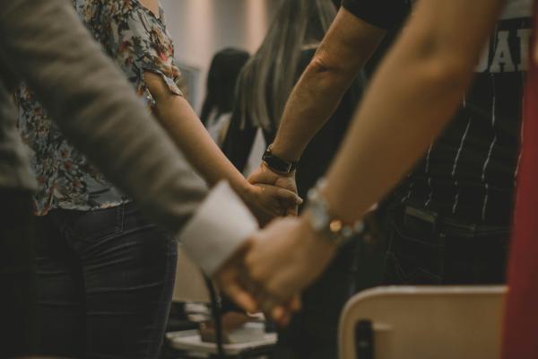 A group of individuals is seen holding hands 