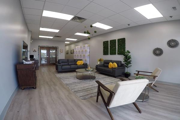 A room is pictured with couches, chairs, and a relaxing ambience