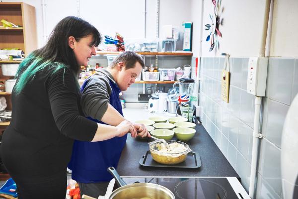 Two people in a kitchen preparing food