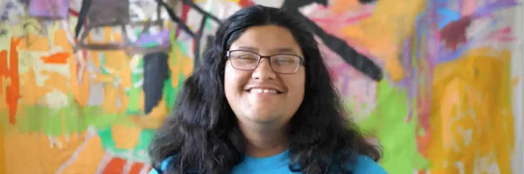 Aida Farias in front of a mural