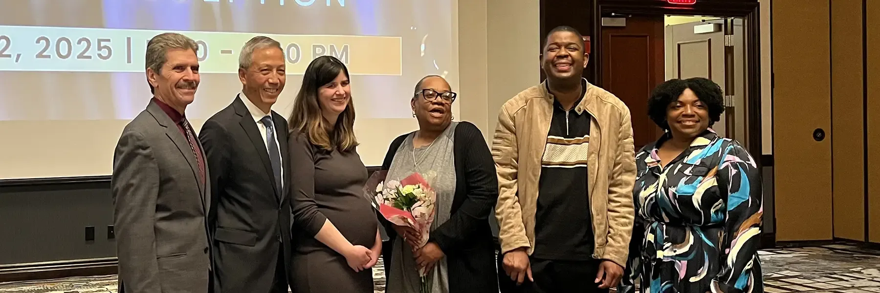A group of six people standing at an awards reception in front of a screen displaying 'The Arc of Illinois 75 Years Awards Reception.'
