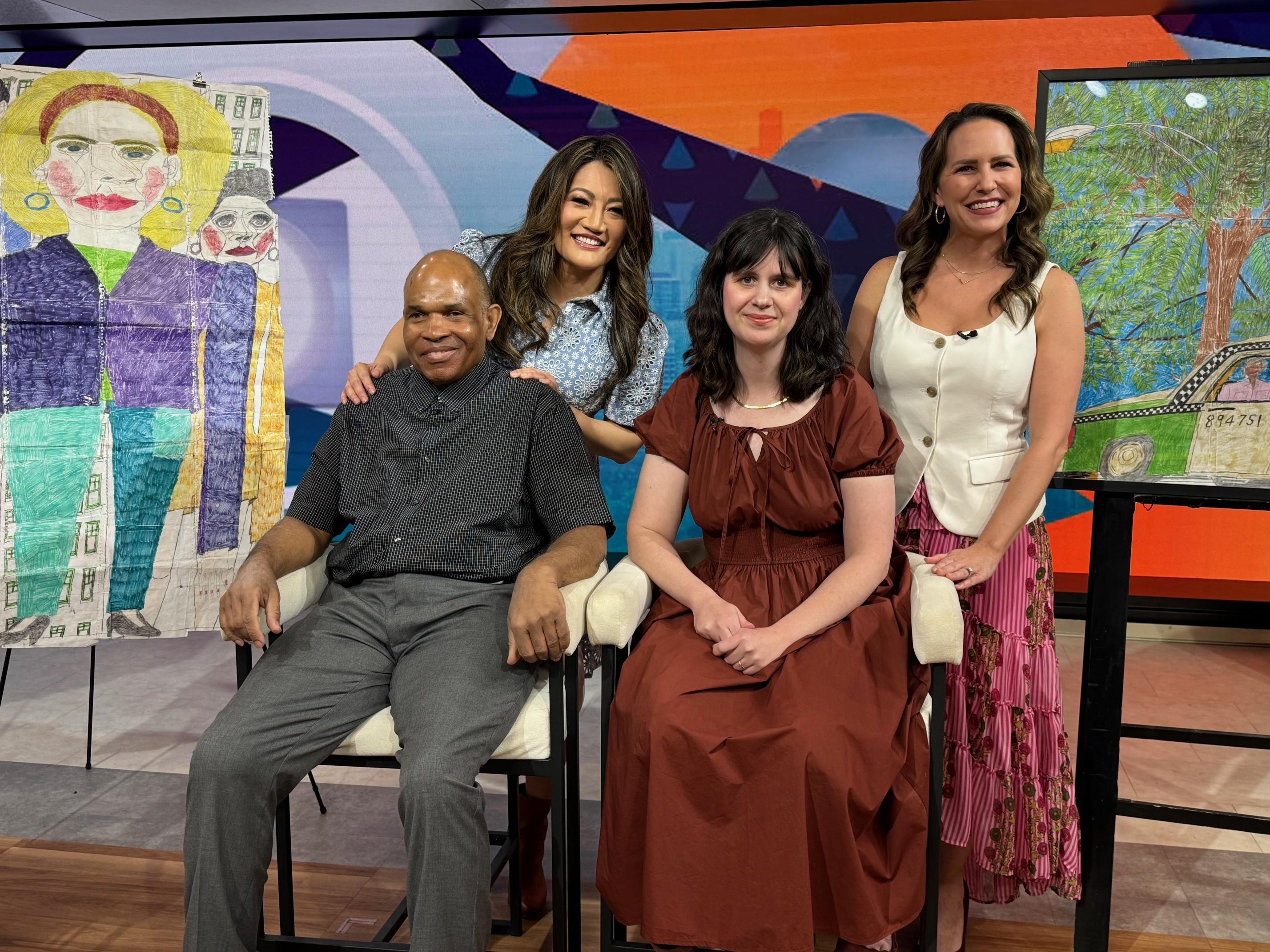 A group of individuals poses behind the scenes at a news studio