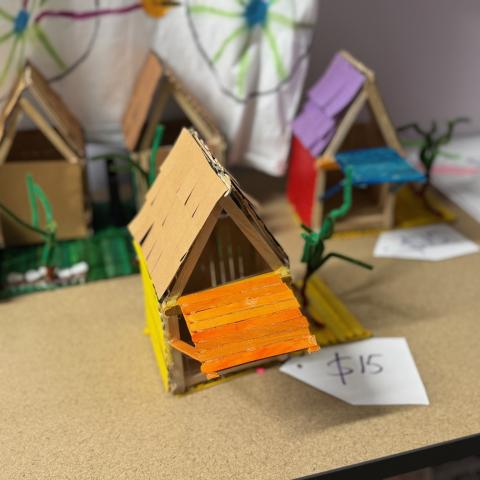 A bird house made of popsicle sticks.