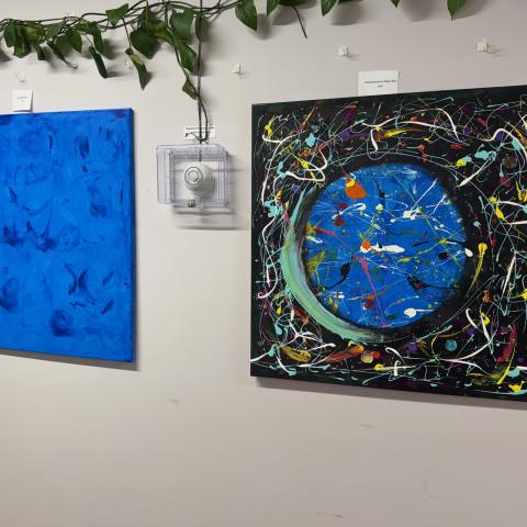 Two paintings hanging on a wall.