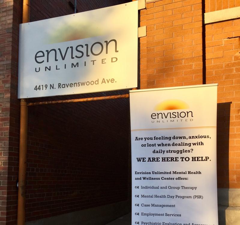 A doorway is depicted with signage from Envision Unlimited