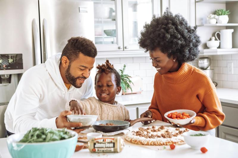 A family is pictured preparing a meal in their kitchen