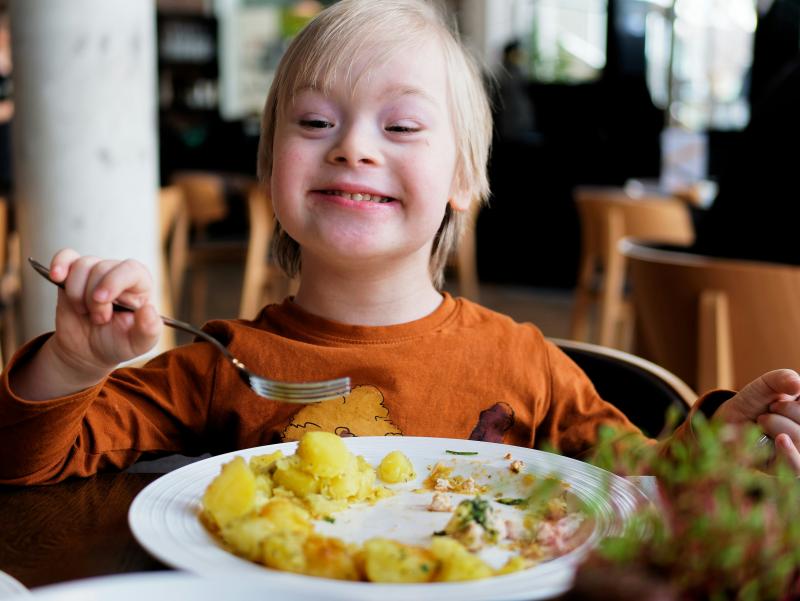 A child is seen happily enjoying a meal