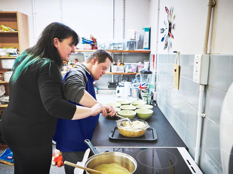 Two people in a kitchen preparing food